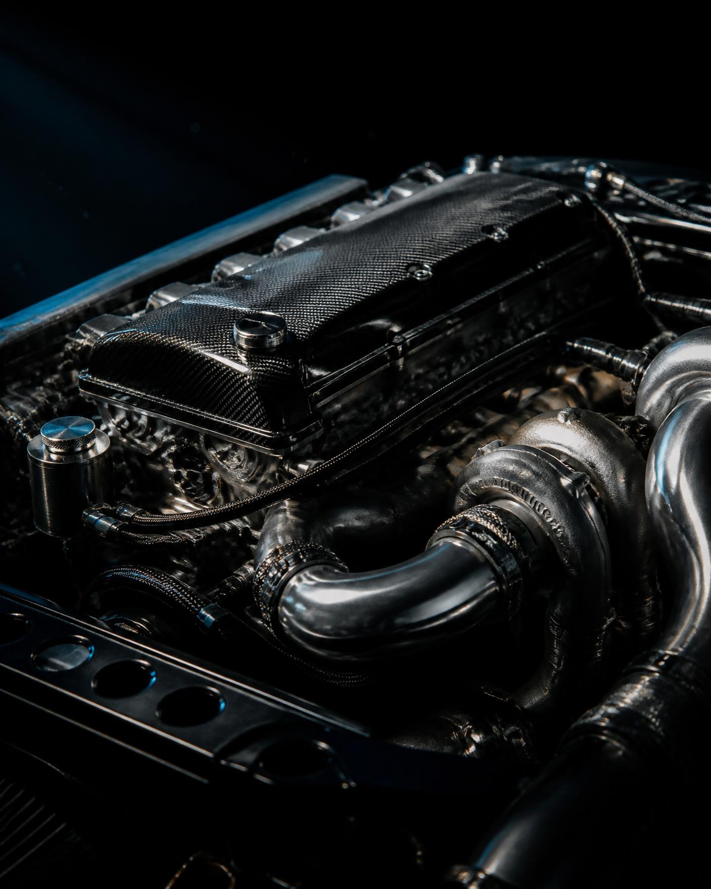 Close up of a twin turbo inline six engine bay with carbon cover